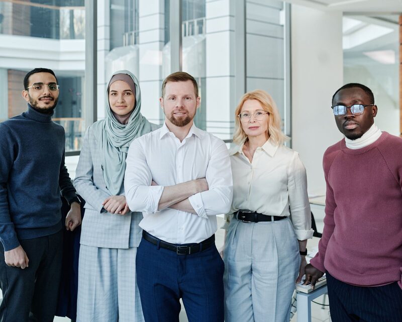 A diverse marketing team standing together in a modern office